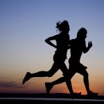 Young couple run together on a sunset