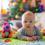 Happy three months old baby boy, playing at home on a colorful a