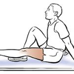 Seated man doing straight leg raise.